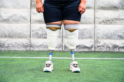 Low section of woman standing on grass