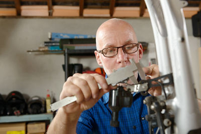 Mature man measuring with equipment at workshop