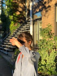 Woman shielding eyes while standing outdoors