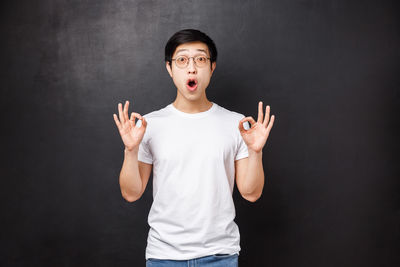 Korean man gesturing against black background