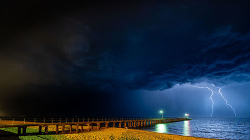 Image of a lightning strike with a pier in the foreground 