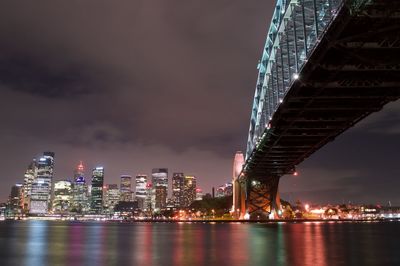 Low angle view of illuminated bridge against sky at night