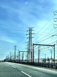 Electricity pylon against cloudy sky