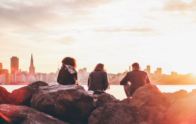 Rear view of people and cityscape against sky