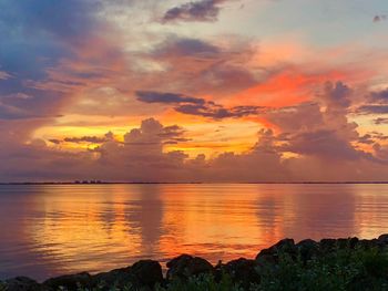 Scenic view of sea against dramatic sky during sunset