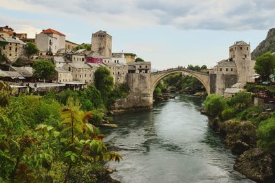 Bridge over river against cloudy sky