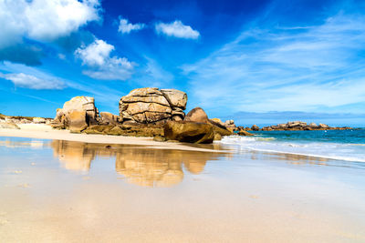 Rock formation on beach against sky