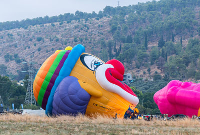 Multi colored balloons on road against mountains