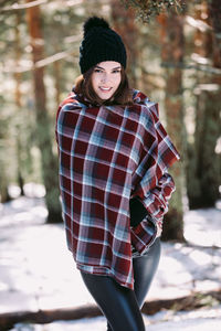 Portrait of beautiful young woman standing in forest