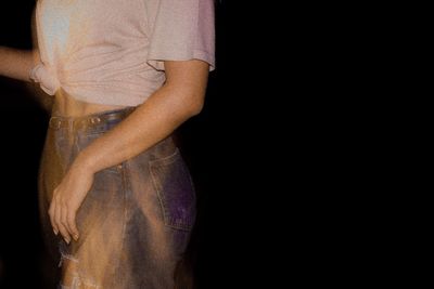 Woman standing against black background