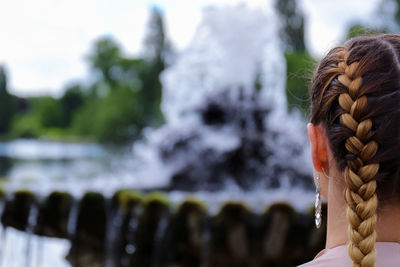 Close-up rear view of woman against water