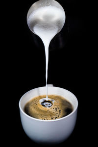 Close-up of coffee cup against black background