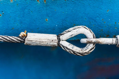 Close-up of steel cable against blue wall