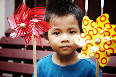 Close-up of cute boy holding pinwheel toys