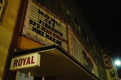 Low angle view of illuminated information sign at night