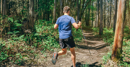 Full length of man photographing in forest