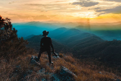 Rear view of man looking at mountain against sky