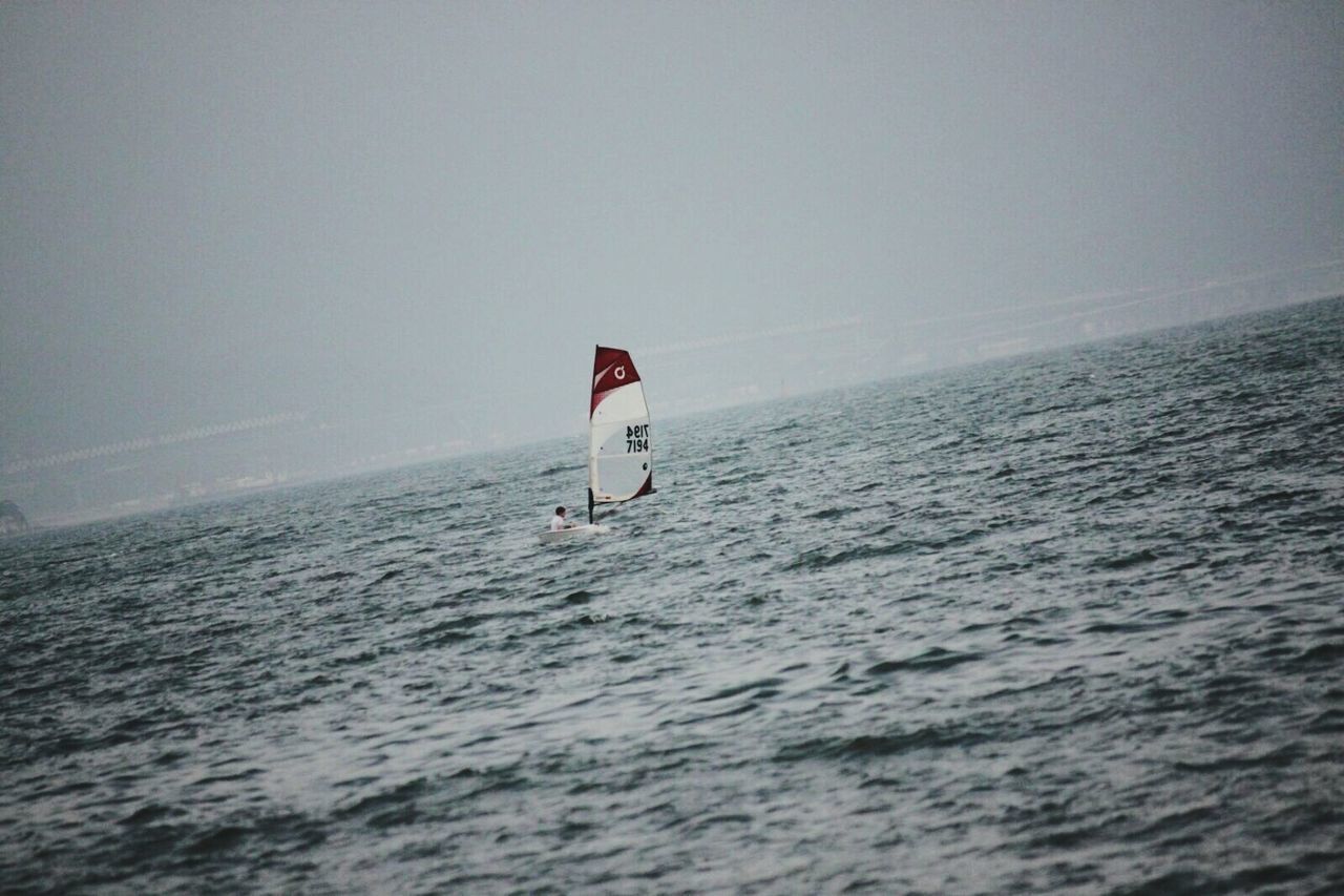 PERSON SAILING IN SEA AGAINST CLEAR SKY