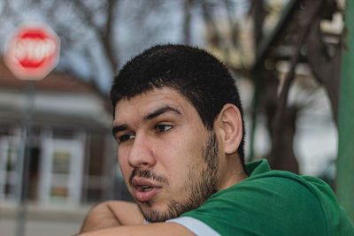 Portrait of young man looking away outdoors