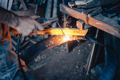 Midsection of man working on metal