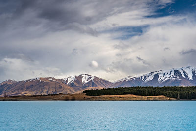 A scenic landscape of new zealand southern alps and lake pukaki with blue sky and clouds.