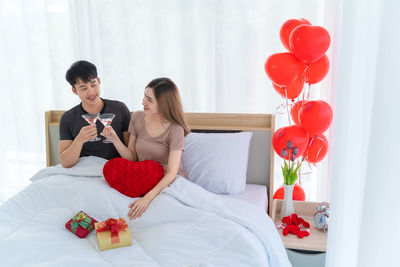 Young couple holding balloons