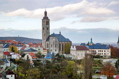 View of bell tower in city against cloudy sky