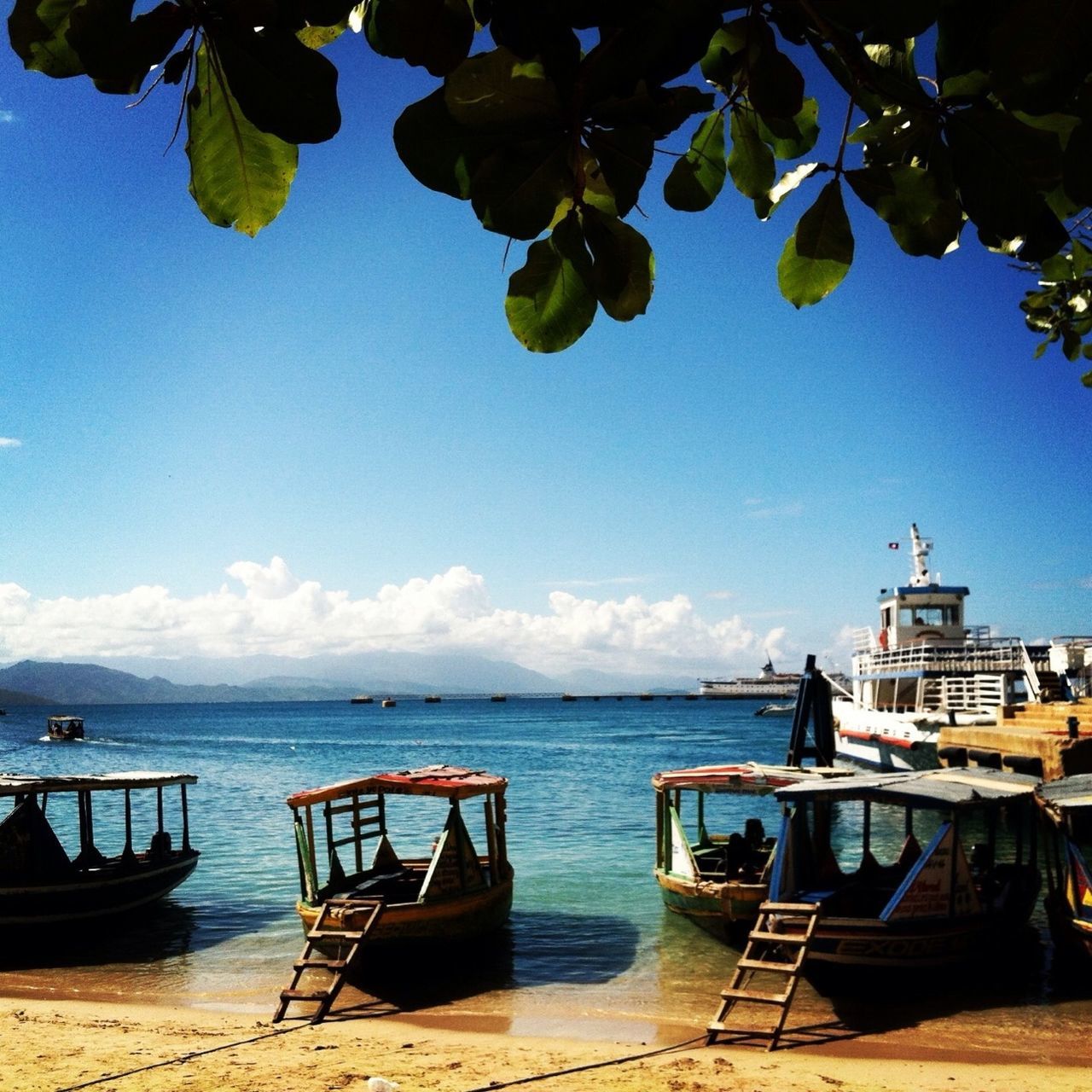 water, sea, nautical vessel, boat, horizon over water, moored, transportation, tranquility, tranquil scene, beach, sky, mode of transport, scenics, chair, beauty in nature, nature, blue, vacations, lounge chair, sunlight