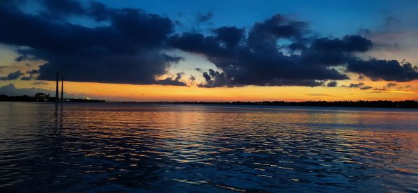 Scenic view of sea against dramatic sky during sunset