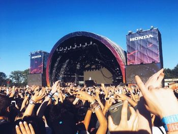 Crowd at music concert against sky