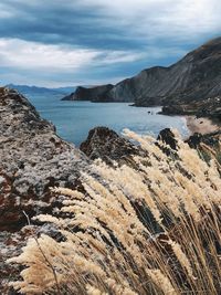 Scenic view of sea and mountains against sky