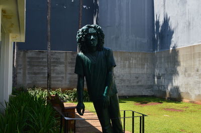 Man standing by statue against building