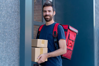 Portrait of smiling mid adult man standing in box