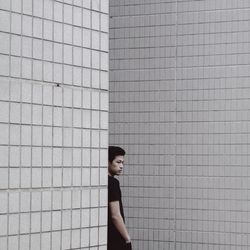 Portrait of young man standing on wall