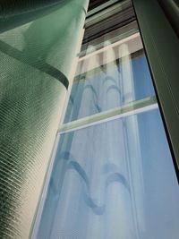 Low angle view of building seen through glass window