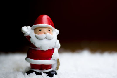 Close-up of figurine on snow during christmas