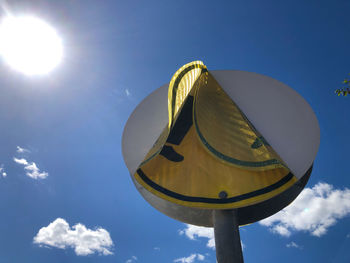 Low angle view of umbrella against blue sky on sunny day