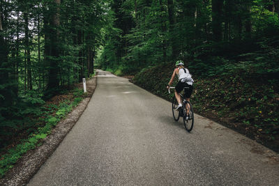 Woman riding her roadbike on road in the austrian alps