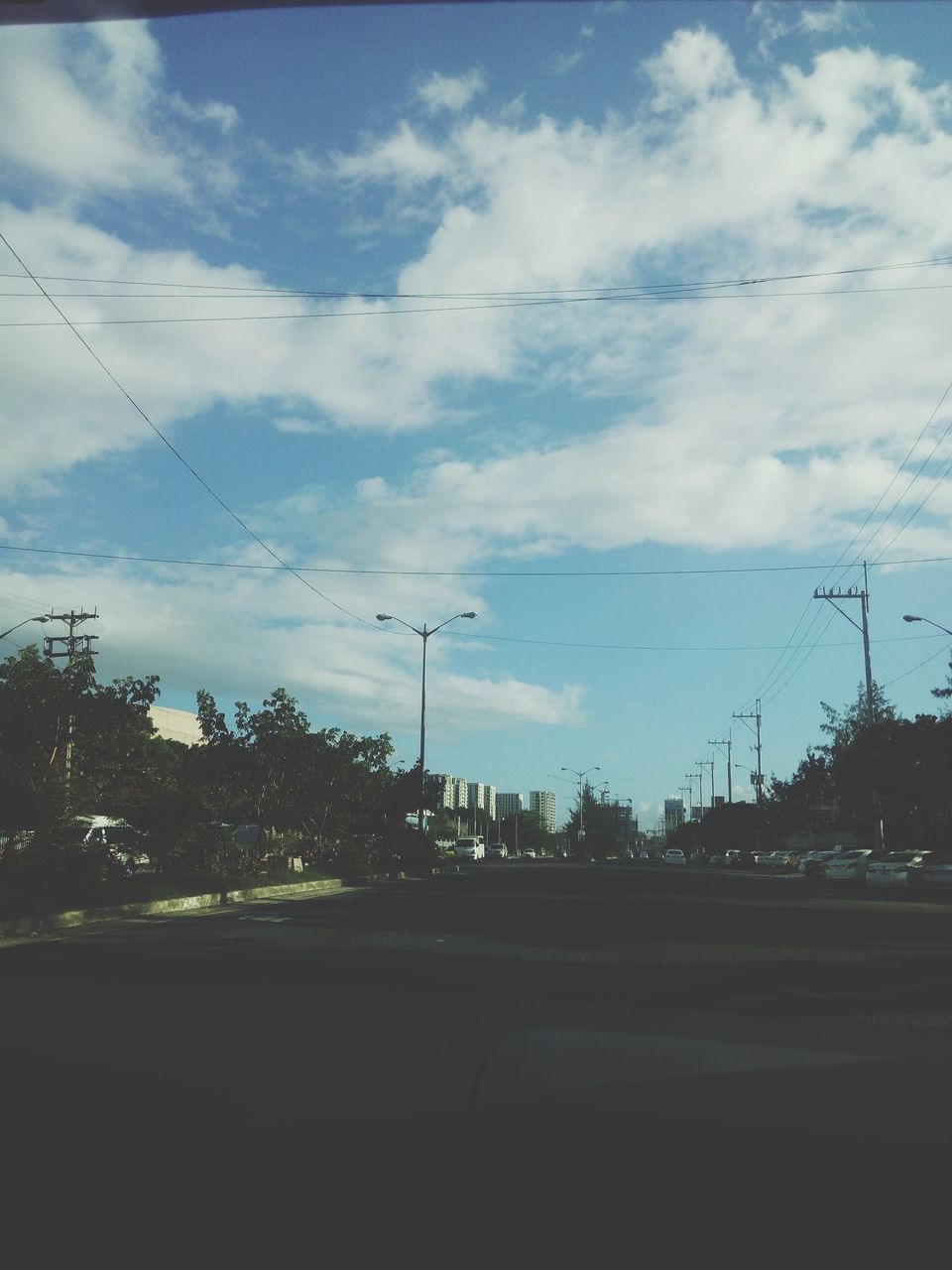 sky, cloud - sky, building exterior, cloud, cloudy, transportation, street light, built structure, tree, street, road, silhouette, car, architecture, city, glass - material, transparent, no people, land vehicle, outdoors