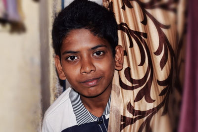 Portrait of boy behind curtain