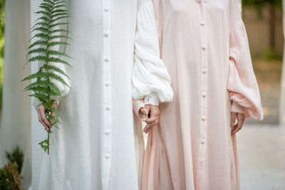 Midsection of women standing with plant