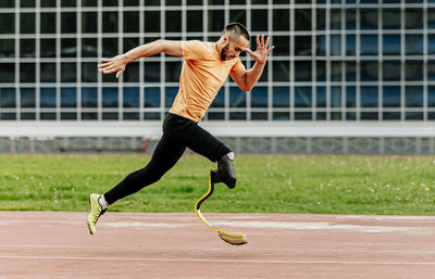 Full length of woman exercising on field