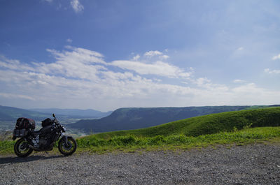 Motor bike on road by mountain against sky