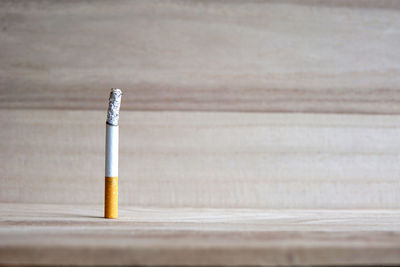 Close-up of burnt cigarette on wooden table