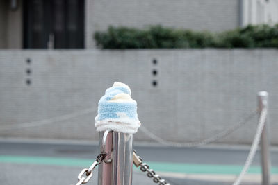 Knit hat on metallic fence