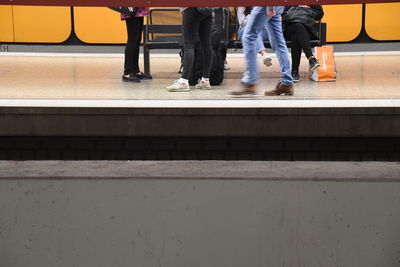 Low section of people walking on railroad station platform