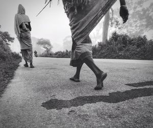 Rear view of people walking on road