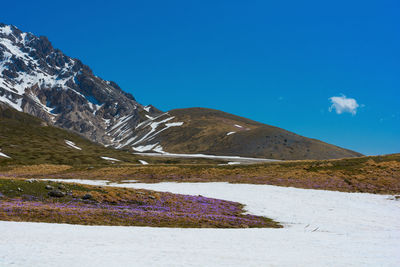 Scenic view of mountains against blue sky