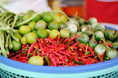 Close-up of green chili peppers in container for sale at market