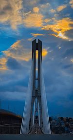 Low angle view of bridge against cloudy sky during sunset